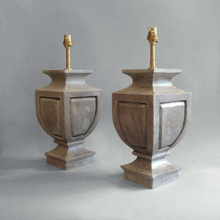 A pair of grey painted carved wooden lamp bases of square tapering form with panelled sides.

These lamp bases take their name from the Chateau d'Amboise in the Touraine, France.