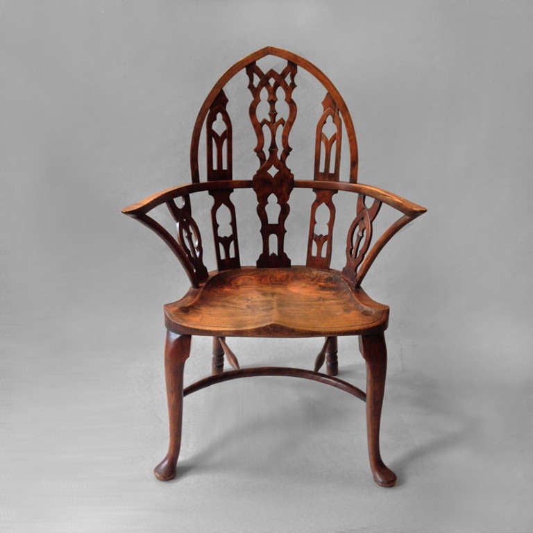 A finely shaped Windsor armchair in the Gothic manner, the pointed arched back with pierced tracery fretwork decoration having armrests, all set upon a solid shaped elm seat and raised upon two cabriole front legs and two turned rear legs with