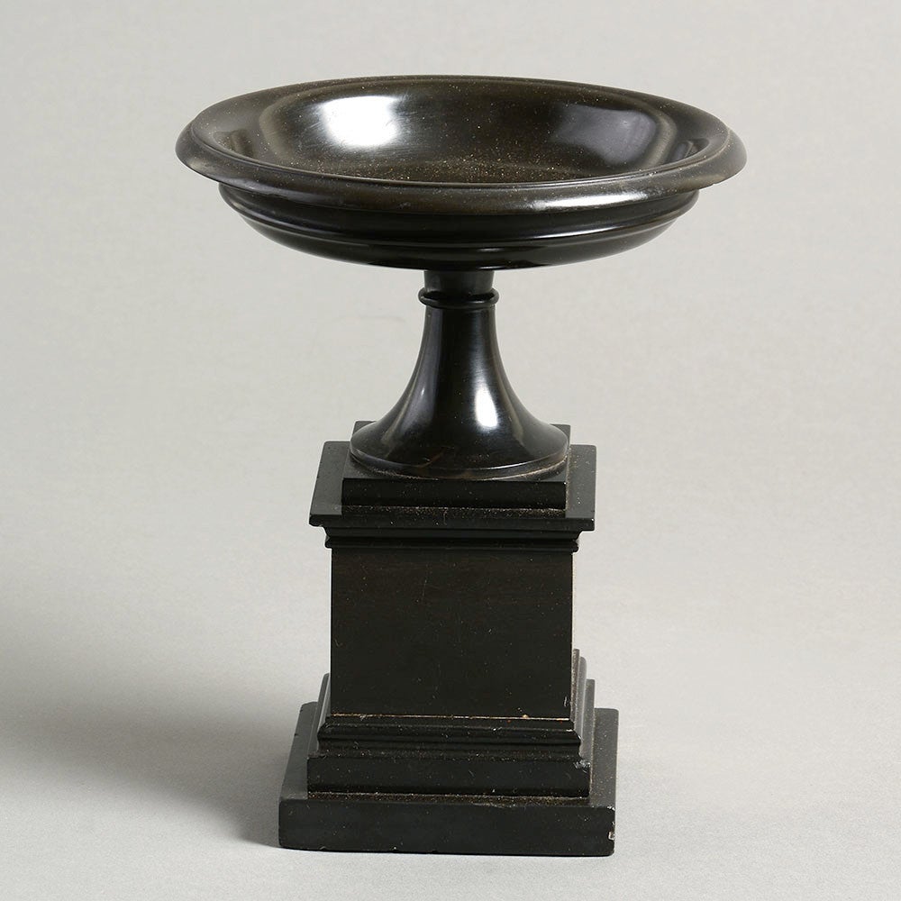 A fine black marble tazza of exceptional quality and condition, the turned upper section set upon a square stepped plinth.

A tazza is a shallow, often wide saucer on a stem or foot, traditionally used for serving small foods, drinking or for