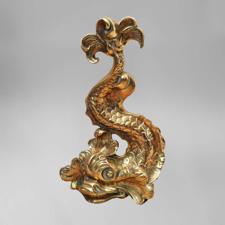 A mid-19th century brass doorstop cast in the form of a stylised heraldic dolphin