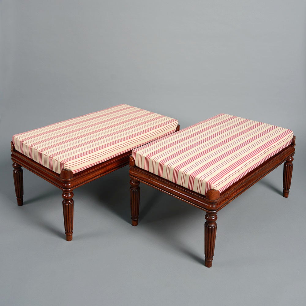 A fine pair of late 20th century rosewood benches in the Regency manner, with drop-in mattress seats all held by acroteria and raised on turned fluted legs.