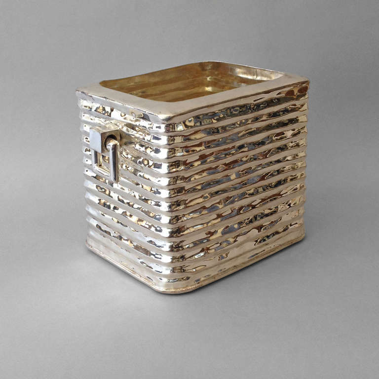 A mid-20th century silvered ice bucket or wine cooler, the corrugated body with square drop handles to either side