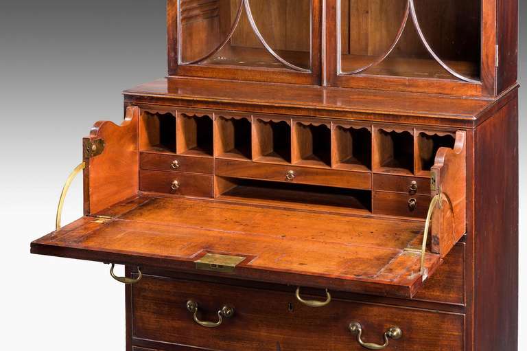 Une belle et originale bibliothèque secrète d'époque Chippendale en acajou de petites proportions, la section supérieure avec des barres de vitrage semi-elliptiques, l'intérieur équipé de trous de pigeons et de tiroirs uniformes, cuir inséré