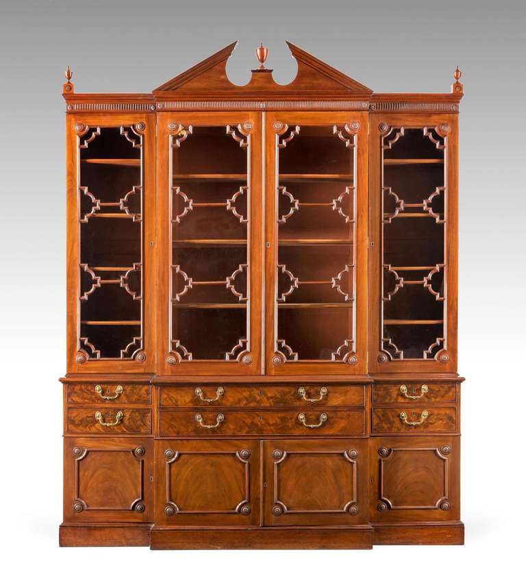 A good Chippendale period mahogany breakfront library bookcase of exceptionally good proportions and with an unusual arrangement of astragal glazing, the secretaire drawer with slide, the main carcase with finely carved roundels and original gilt