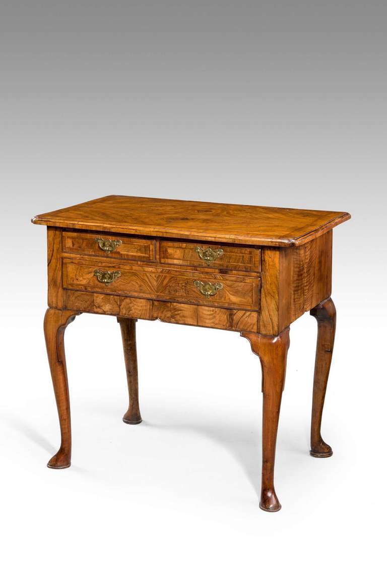 A good George I period walnut lowboy, the quartered top with crossbanding and inset corners, the three drawer fronts banded and crossed banded, the overall timbers extremely well figured standing on cabriole supports terminating in pad feet.

RR.