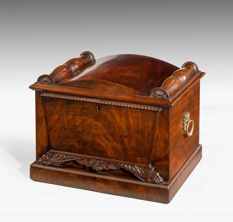 A fine quality Regency period mahogany wine cooler of sarcophagus form, the top with two half roundels flanking the domed section, well figured timbers on scrolled feet above the plinth with excellent original gilt bronze side handles.

