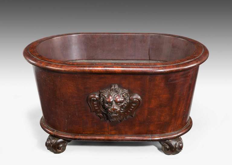 A substantial late Regency period mahogany wine cooler, the well carved central motive of a lion, the whole standing on scroll feet.

RR.