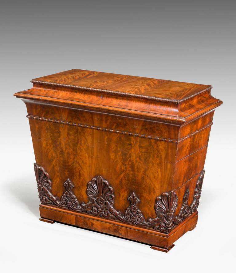 A very finely figured early Biedermeier wine cooler of substantial size, the matching flame timbers of exceptional quality, the lower section with a very finely carved border stylized anthemion leaves standing on a block plinth with flat square