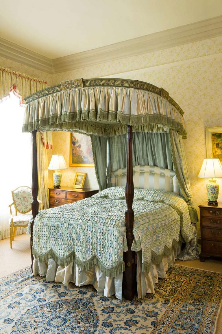 George III period mahogany and painted four-poster bed, formerly the property of the Lord Menuhin. The well carved uprights with reeded decoration with palmets and anthemion leaves, the bowed cornice with largely original paintwork incorporating