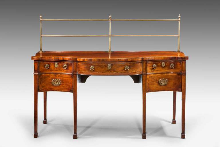 George III period serpentine mahogany sideboard of quite exceptional color and patina, the top edge cross banded, the drawer fronts with slender crossbanding in kingwood edged in boxwood, beautiful original brass ware.

