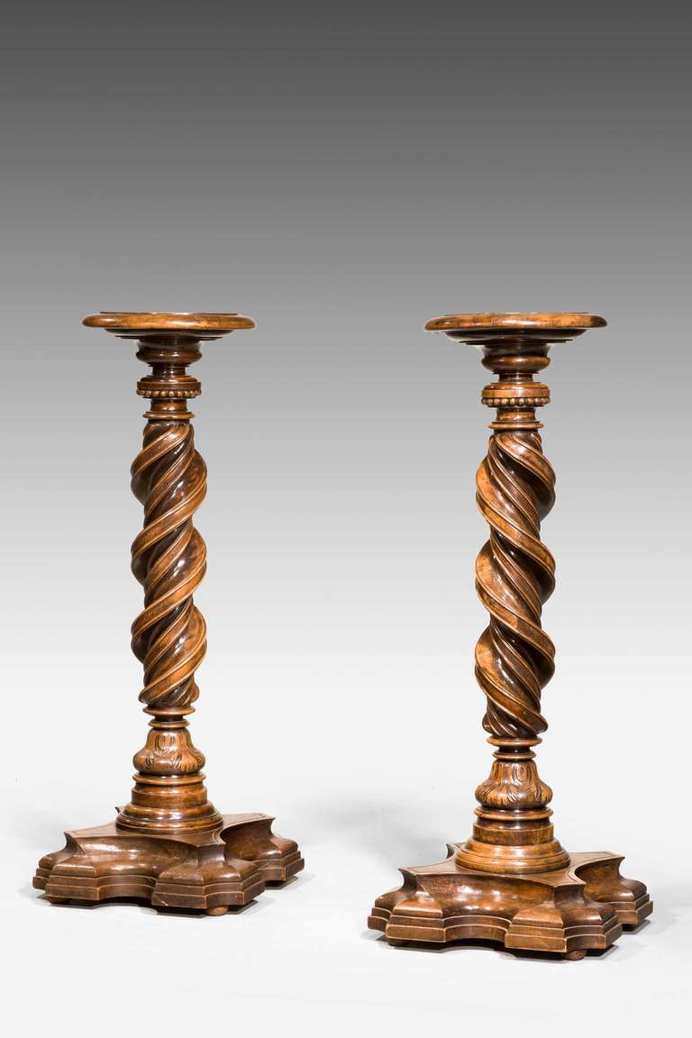 An exceptional pair of Italian walnut torcheres, the central writhen sections of wonderfully faded timbers from the 17th century, the tops and platform bases sympathetically designed but of the 19th century. 

Torcheres were used as stands for