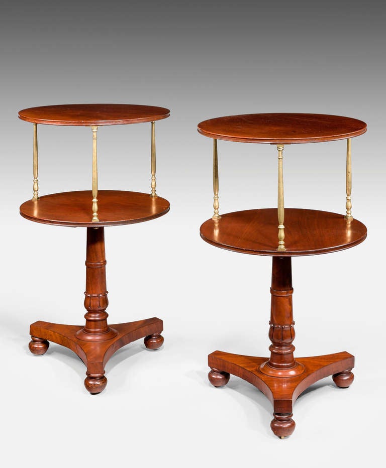 An attractive pair of Regency period dumb waiters, the well figured shelves with brass supports, the pillars ringed turned over triform bases. Very good color and patina.

  