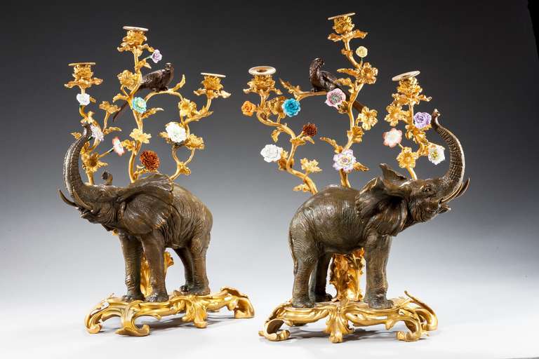 Splendid pair of bronze and gilt bronze elephant candelabra, the elaborate Rococo of flowers and foliage with birds in the branches, mid-20th century.