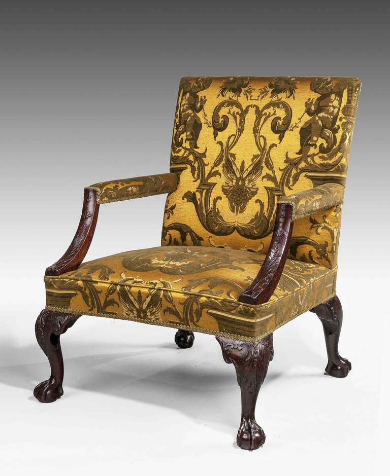 A Chippendale period mahogany 'Gainsborough' armchair with blind fret carving on strongly swept arm supports, finely carved knees over claw and ball feet, in parts re-railed.

A Gainsborough armchair (also known as a Martha Washington chair in the
