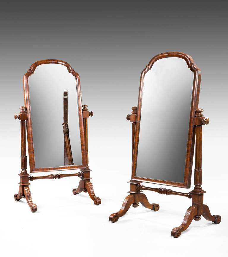 A rare pair of mid-19th century Children's Cheval mirrors, the frames entirely cross grain timbers, the supports with deep incised decoration terminating in scroll feet. Fine condition.

