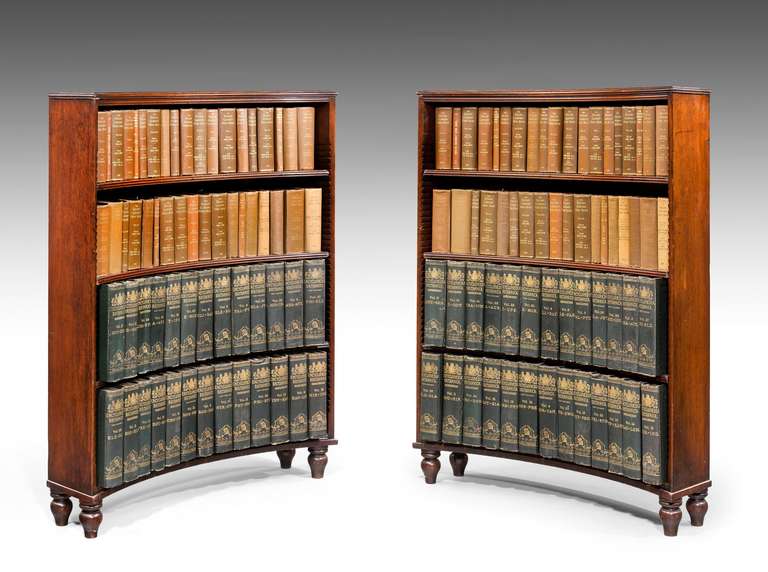 A rare and original pair of George III period mahogany concave open bookcases, reeded shelves over original turned feet. Wonderful color and patina.

Please note: The books inside the bookcases are not for sale and are for display purposes
