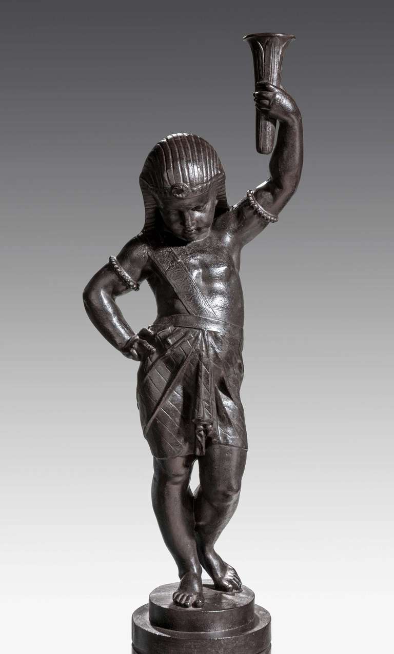 A fine bronze patinated cast iron figure on a fixed pedestal of an Egyptian boy holding a torch by Val D'osne. 

Val Osne is a deviation from the common Osne-le-Val in Haute-Marne. Workshops, created in 1836 by Jean-Pierre Victor Andre to make