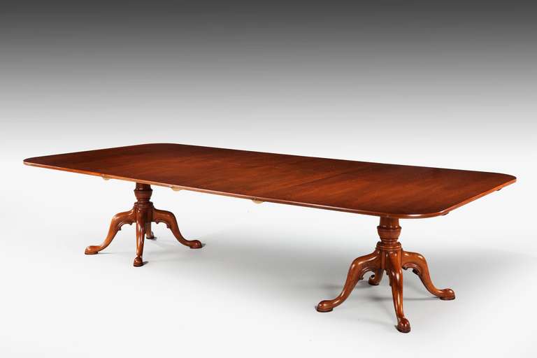 An unusual, large mid-20th century mahogany two pillar dining table on substantial turned supports with cabriole legs terminating in pad feet. Two original leaves supported by bearers.

