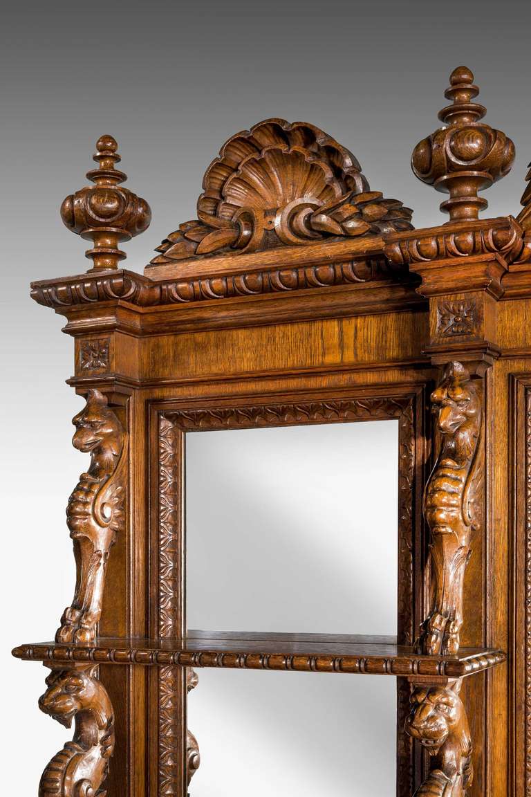 A quite magnificent, late 19th century, oak sideboard, the base section incorporating three serving slides with inset marble centres, the doors carved in high relief with foliage and fruits. The end cupboards fitted with drawers and sliding trays,