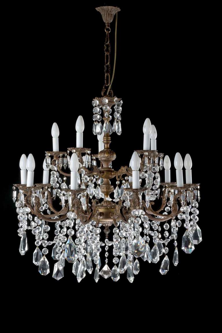 A good late 19th century, crystal and gilt bronze fifteen-arm chandelier, the metal in original state and well patinated, the arms cast with elaborate scrolls with massive finely cut lozenges.
The earliest candle Chandeliers were used by the wealthy