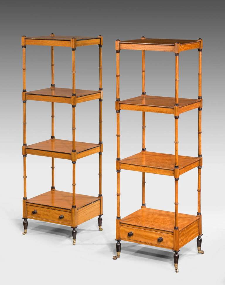 A matching pair of early 20th century satinwood four height whatnots, delicately turned uprights with ebonized sections matching the edge of the shelves, both with single drawers.

RR.