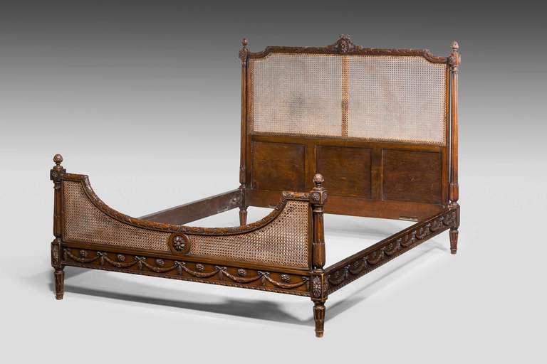 A good Bergere mahogany Double Bed, the top and the base with inset carved panels in excellent condition. The top edges of the head-board and foot-board well carved with wreath and cartouche decoration, the sides with carved harebells.