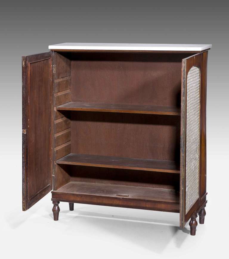 A very slender Regency period mahogany Side Cabinet, the silk lined doors with chicken wire panels on short toupee feet with two adjustable shelves behind the doors.
The interior depth is 9 inches