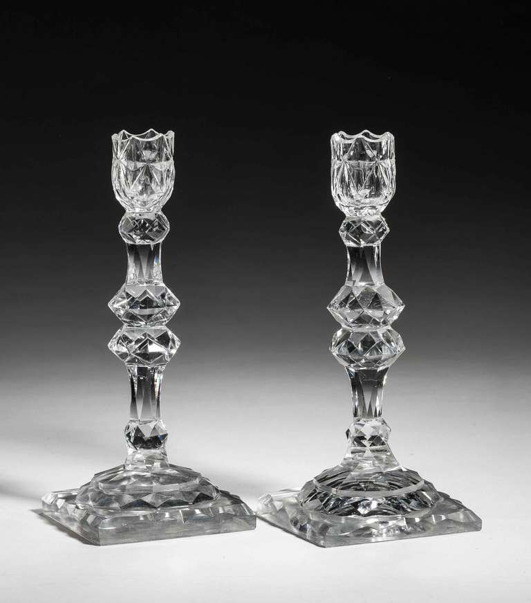 Fine pair of Irish 18th century glass candlesticks decorated with prismatic stems on square stepped bases.