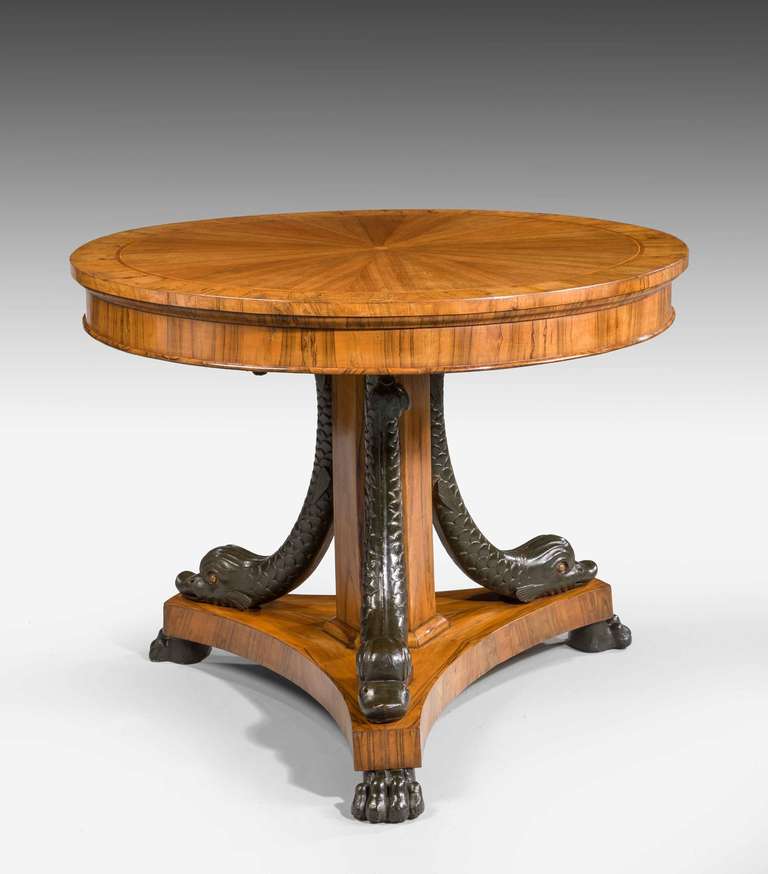 A good 19th century olivewood and walnut centre table, the base with supporting dolphins over a triform. Wonderful color and patination.


