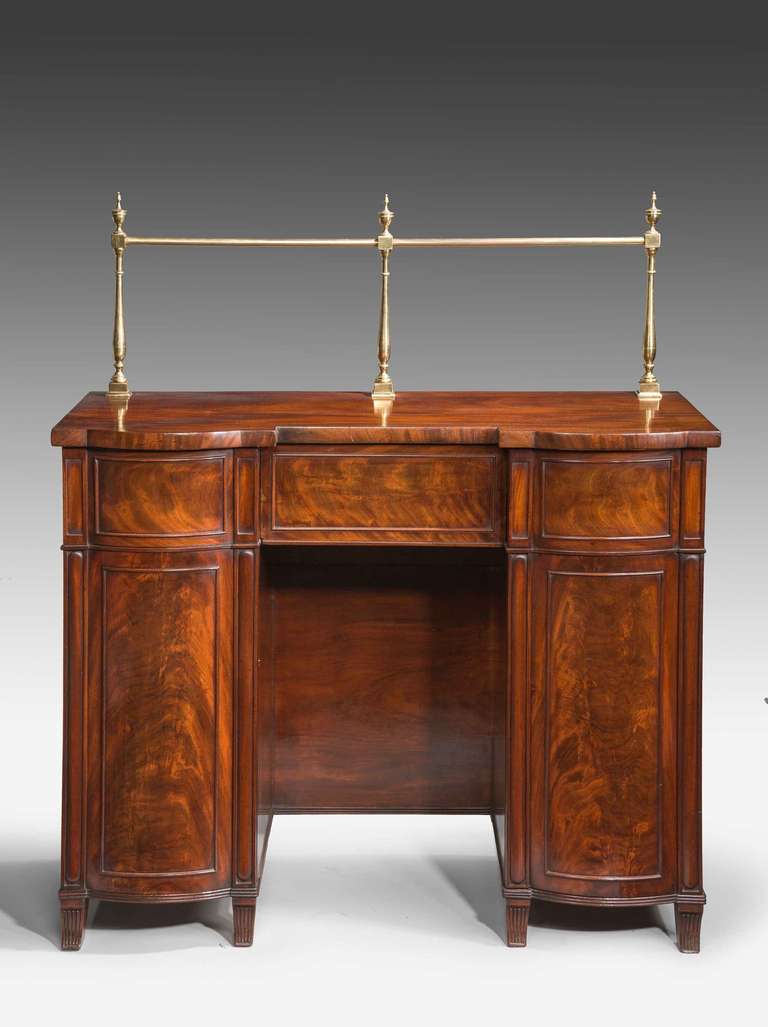 Most unusual Regency period mahogany sideboard, the two bow ends concealing cupboards one with a bottle drawer, finely figured veneers on short reeded sabre supports.

RR