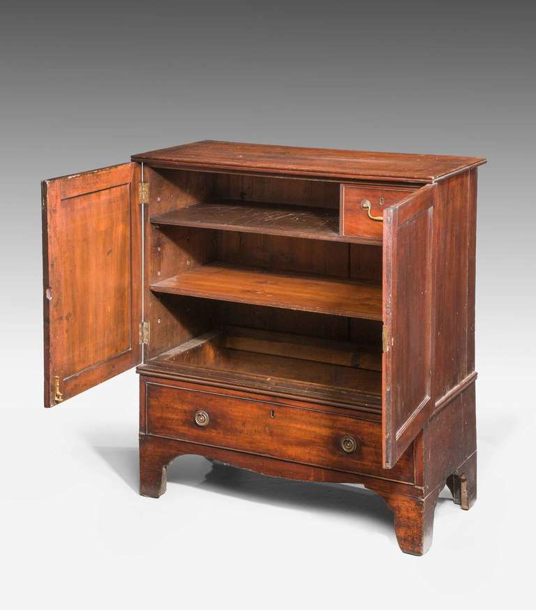 George III period mahogany dwarf press, the base section with a faux drawer, behind the two doors two shelves and a single drawer.