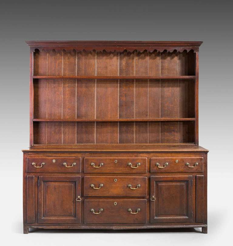 Late 18th century oak dresser and rack, the base with fielded panel doors and five drawers, the Delft rack top backboards with later early 20th century boards.

A Welsh dresser sometimes known as a kitchen dresser or pewter cupboard, is a piece of