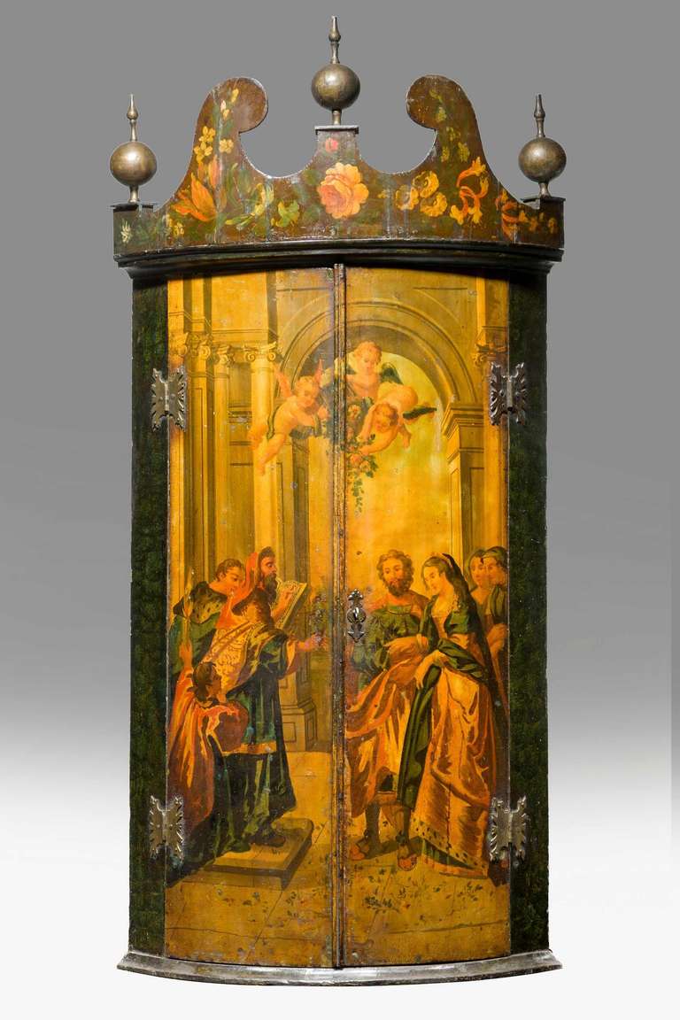 An unusual late 18th century Dutch painted corner cupboard with an exaggerated shaped pediment top, the front with a court scene in oils. Excellent overall condition.