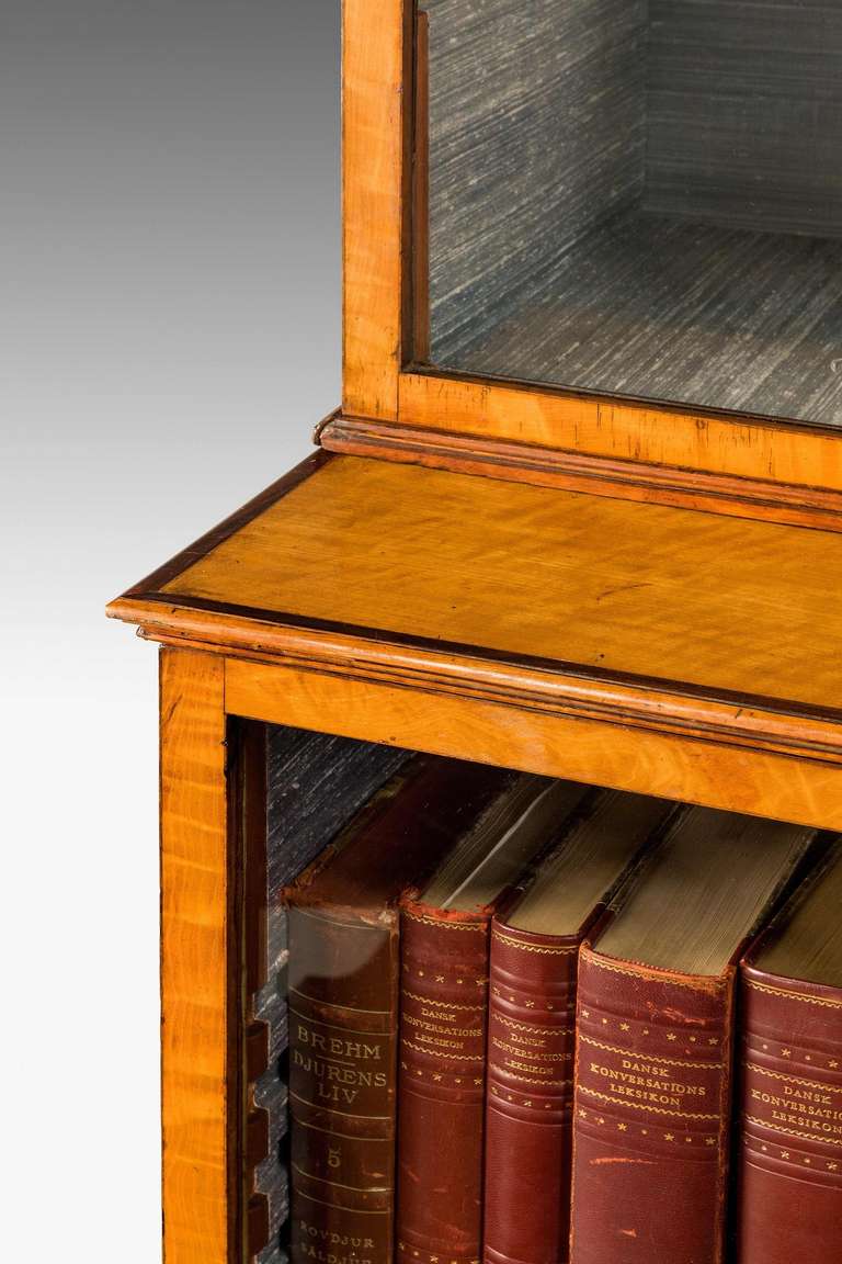 A good George III period satinwood bookcase, the stiles of particularly fine construction with delicate astragals, the top section of the base crossbanded in rosewood on original turned feet, the whole of very fine proportions.