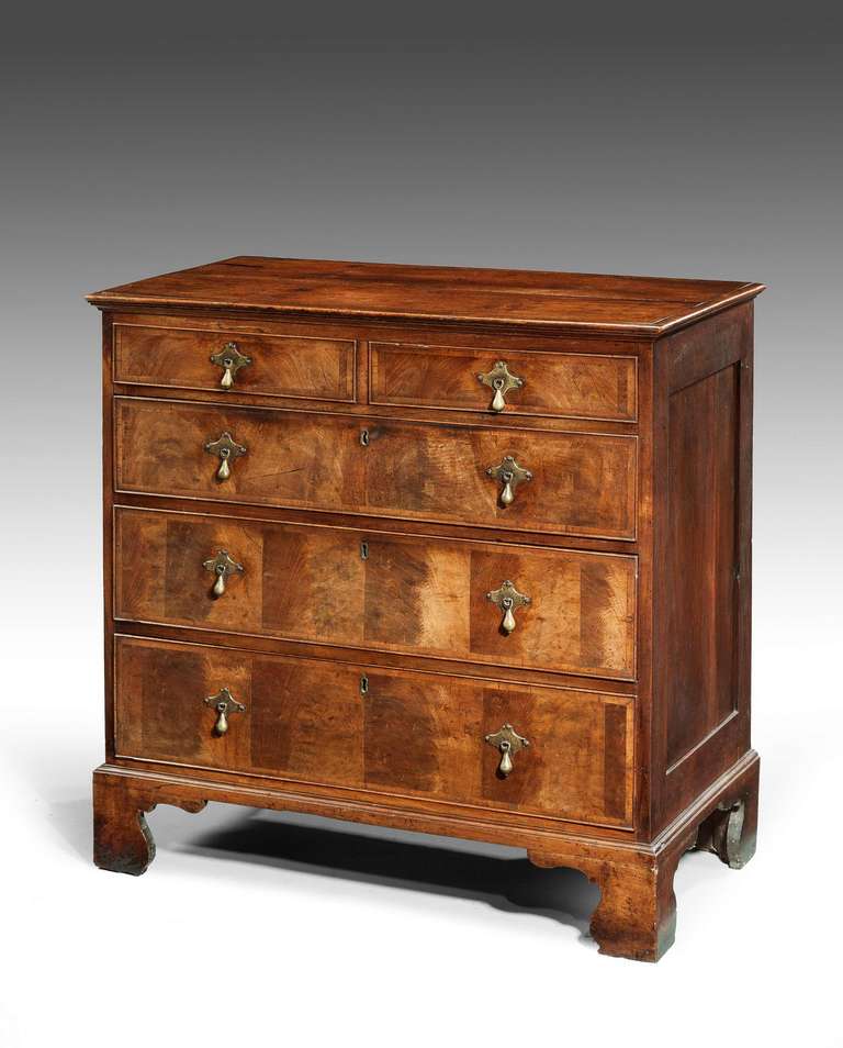 A well figured mid-18th century Walnut Chest of Drawers of very good colour and patina, the drawer fronts cross banded with pear drop handles suspended on engraved back plates standing on high shaped bracket feet.

RR