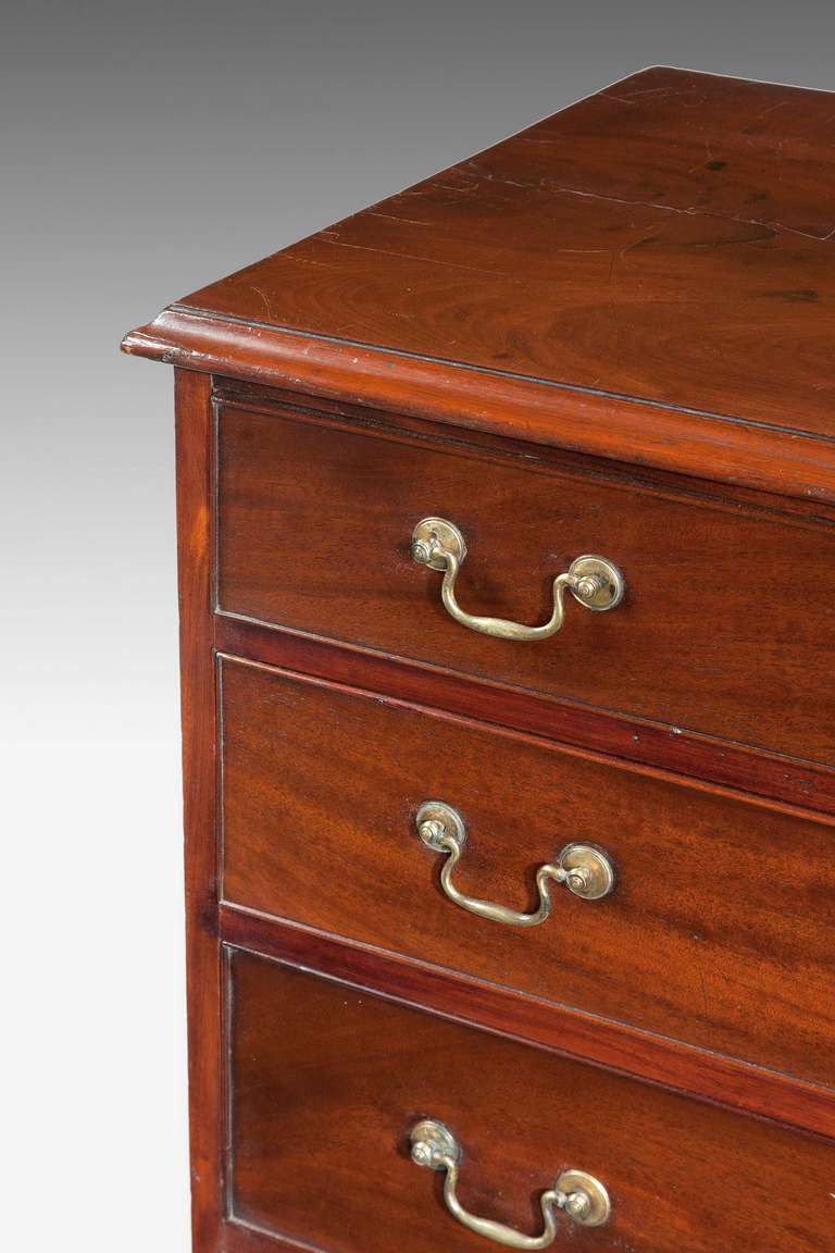 A good George III period straight fronted mahogany Chest of Drawers with original period swan neck handles standing on ogee bracket feet with a moulded top edge.