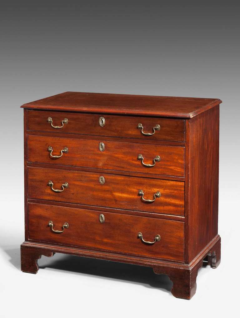 A good George III period straight fronted mahogany Chest of Drawers with original period swan neck handles standing on bracket feet with a molded top edge.