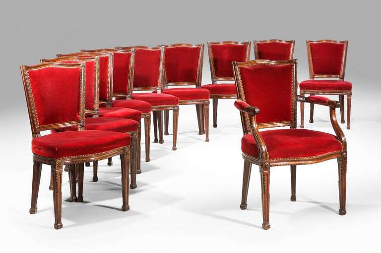 A good set of 18 (16 plus two) mahogany framed chairs, the shield shape backs well carved and with continuous bead decoration, the tapering chamfered supports with an oval paterae to the top section, late 19th century.