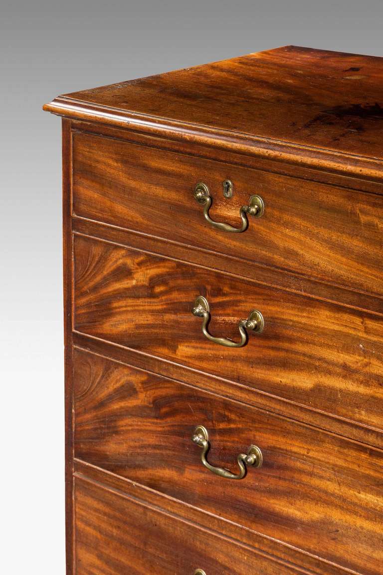 A George III period mahogany Chest of Drawers, the drawer fronts showing strong contrasting striations, good colour to the top over a simple moulding with period swan neck handles standing on well shaped bracket feet.