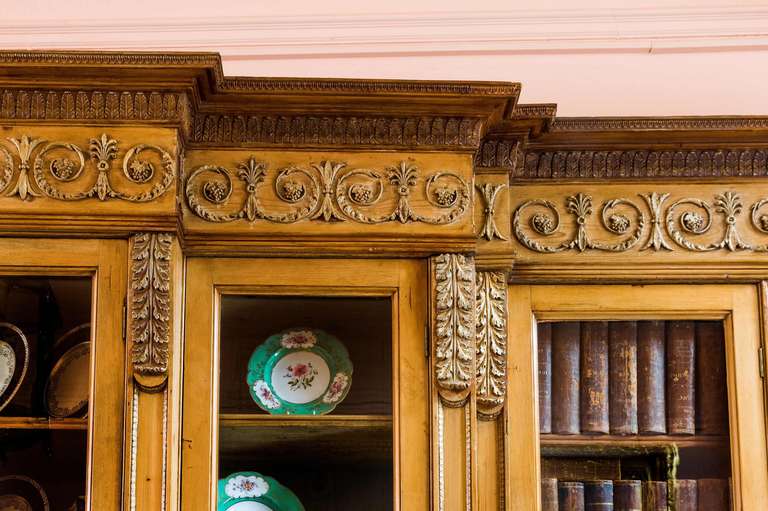An 18th century triple breakfront bookcase, in pine with anthemion and scroll carving to the pediment in overall wonderful condition.

