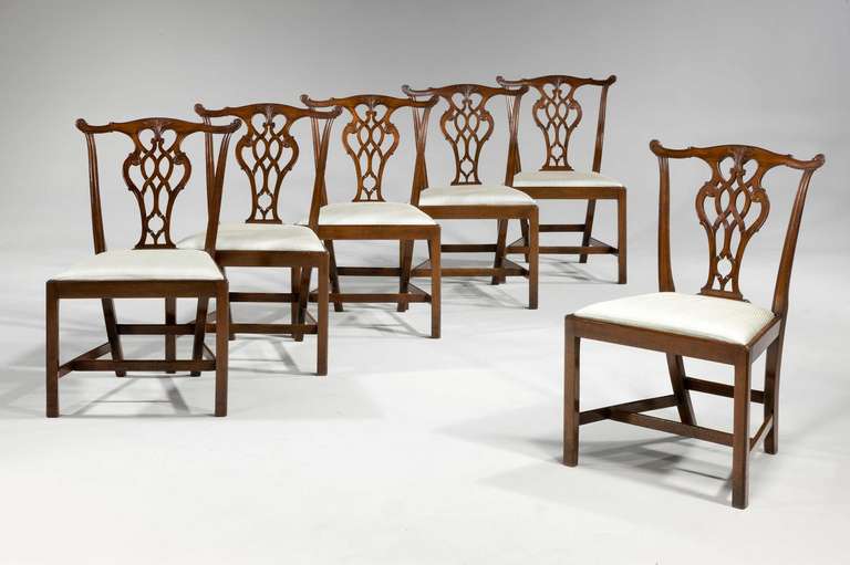 A set of six mahogany framed dining chairs of Chippendale design, the pierced splats below a serpentine top rail with flared and pronounced ears.

RR.