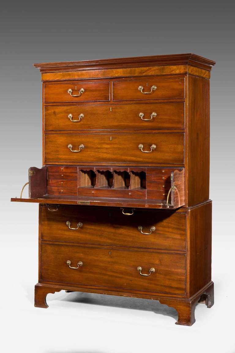 George III period mahogany secretaire chest on chest, the top with a cavetto molding over a highly figured cross banded border, the interior with numerous drawers and pigeon holes standing on bracket feet.

RR.
