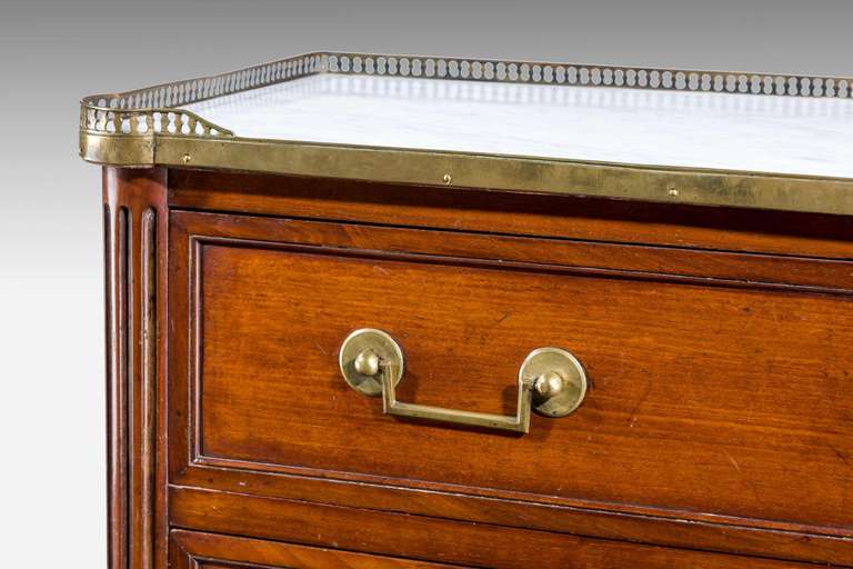 A Louis XVI mahogany Seminaire, the top with an original pierced gallery and inset marble surface, the inset drawer panels with contrasting timbers on the outer edge, period square section brass handles.Original brass mounted turned feet.
