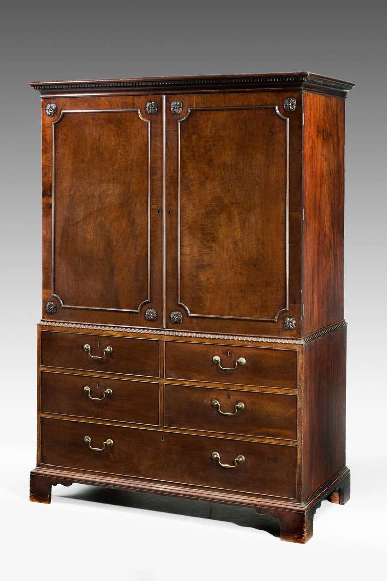 A fine Chippendale period mahogany press, the waist with flared swept moulding, the timbers finely figured, original swan neck handles and bracket feet.