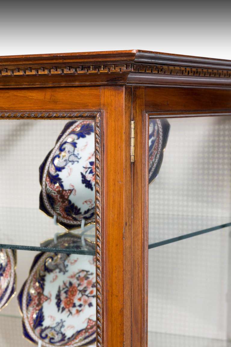 A George III style mahogany china cabinet of 1780 design, the front with fine inlaid boxwood marquetry decoration over delicately carved edging, pierced corner brackets with tapering and inlaid supports.

The items inside the cabinet are not for