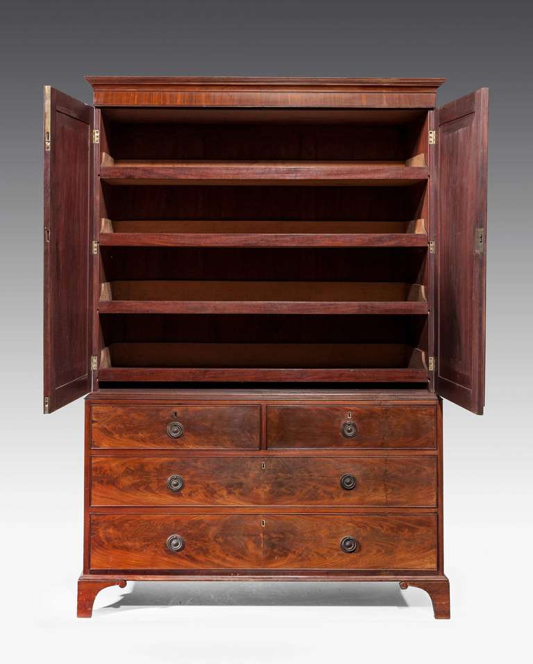 A finely figured George III period mahogany press, the interior with four original sliding trays on slender shaped bracket supports.