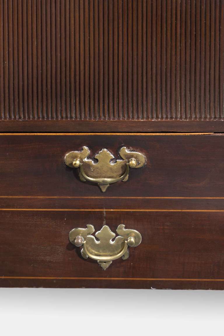 An attractive Chippendale period mahogany tambour fronted Night Cupboard, the top incorporating a wavy border on square chamfered supports, the commode section behind an opening drawer, excellent colour and patina.

