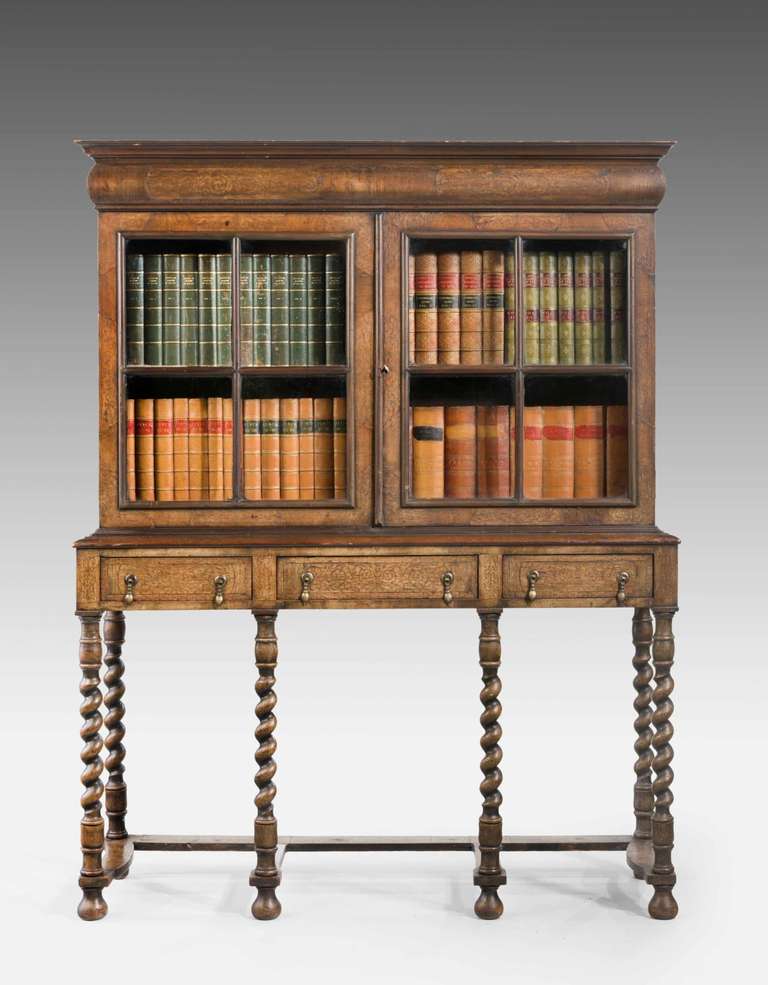 An unusual walnut William and Mary style marquetry cabinet bookcase on writhen supports joined by flat stretchers.

RR.