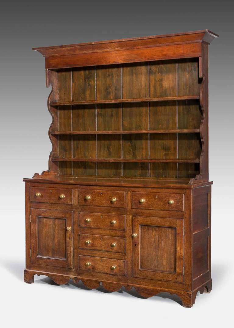 An attractive 19th century oak dresser and rack, the base incorporating six drawers and a pair of cupboards with recess panels, the delft rack with shaped supports and incised shelves for plates.

A welsh dresser sometimes known as a kitchen