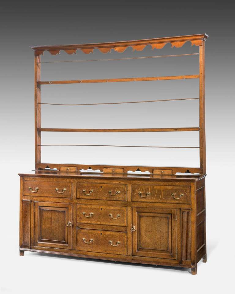 Good George III period oak dresser and rack incorporating five drawers and a pair of panelled cupboards, incised pillars to the outer edge, three spice drawers to the rack, excellent overall condition.

A Welsh dresser sometimes known as a kitchen